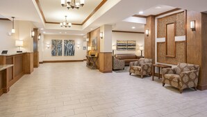 A spacious lobby with a reception desk, seating area, artwork, and a chandelier. - Holiday Inn Express & Suites Glendive by IHG (Glendive)