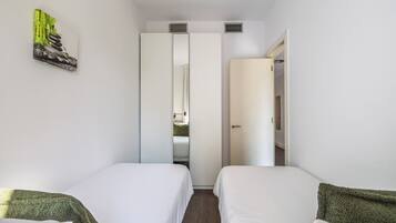Ett hotellrum med två sängar, en garderob och en tavla på väggen.
