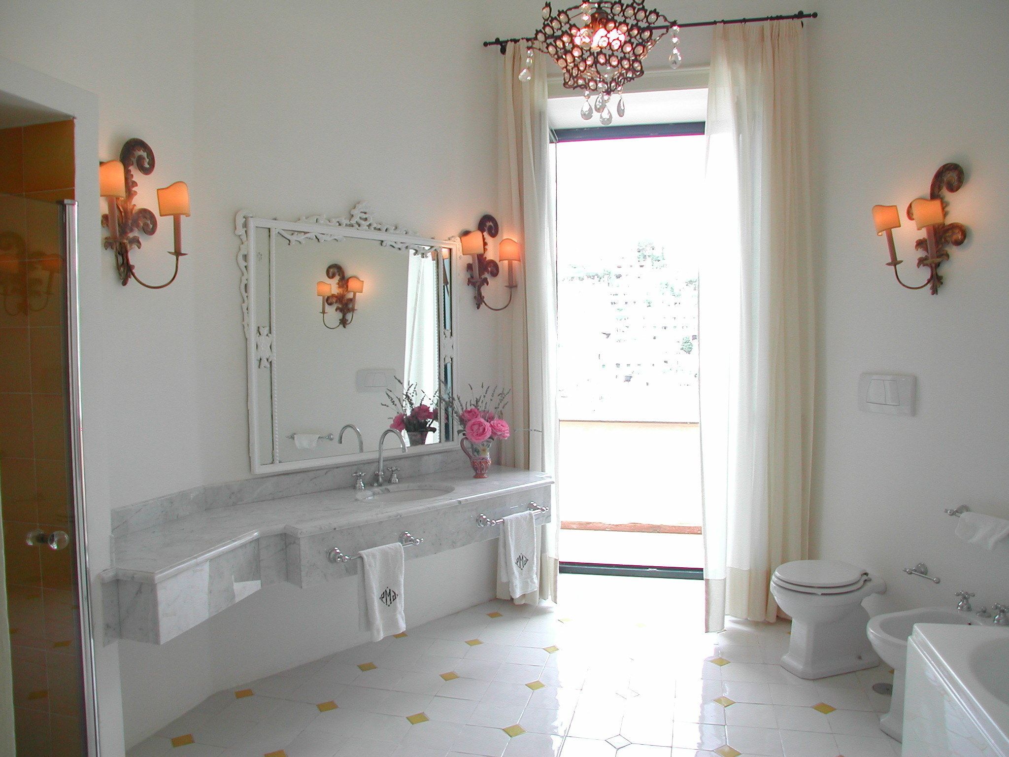 A bathroom with a large mirror, two sinks, a toilet, and a bathtub.