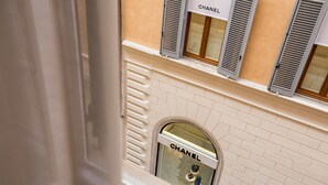 A view of a building with a Chanel store window, a white door, and a brick wall. - Rome55 - Piazza di Spagna (Rome)