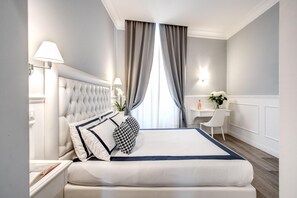 A neatly arranged hotel room with a large bed, a desk, and a chair. - Rome55 - Piazza di Spagna (Rome)