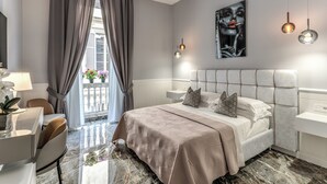 A modern hotel room with a large bed, a desk, and a balcony with plants. - Rome55 - Piazza di Spagna (Rome)