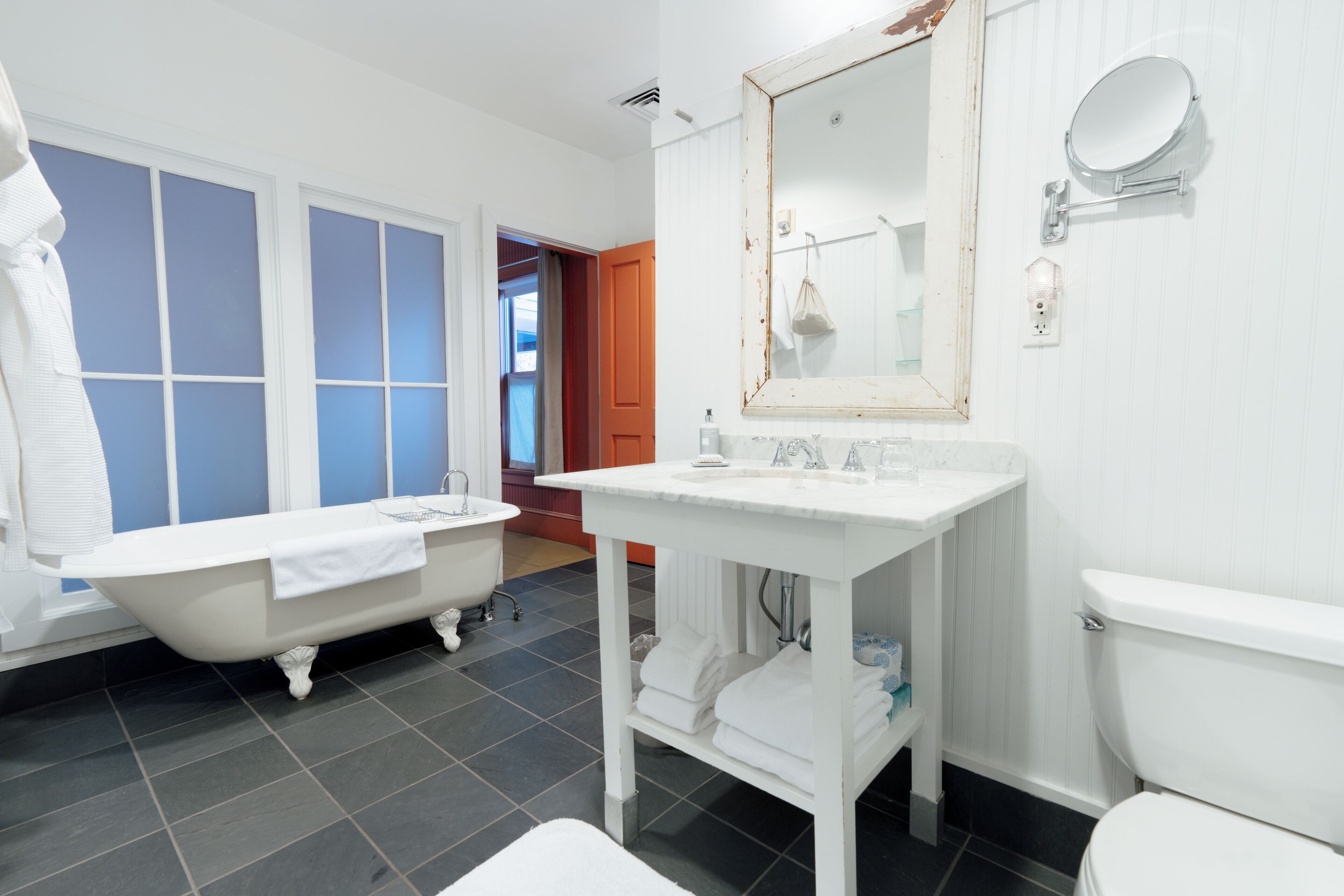 A bathroom with a bathtub, a sink, a toilet, and a mirror.