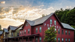 A row of colorful Victorian-style houses with a prominent red one labeled "PORCHES." - The Porches Inn at Mass MoCA (North Adams)