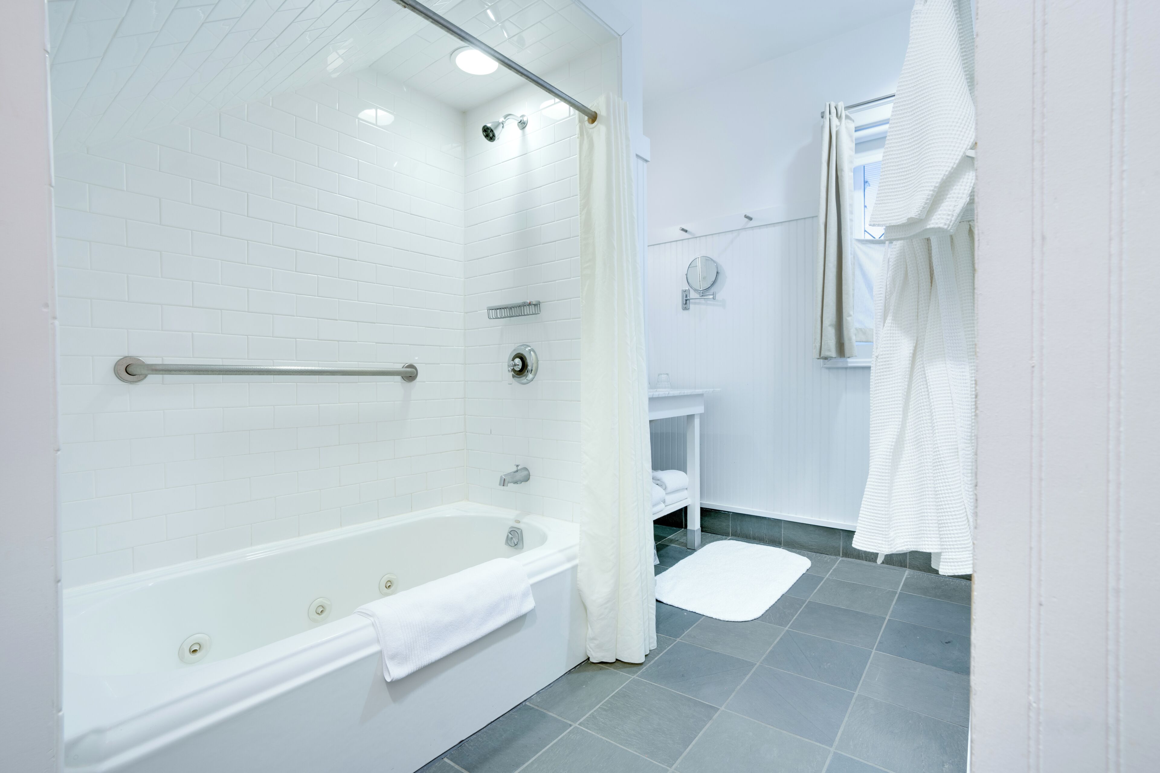 Un baño moderno con una bañera blanca, zona de ducha y lavamanos.