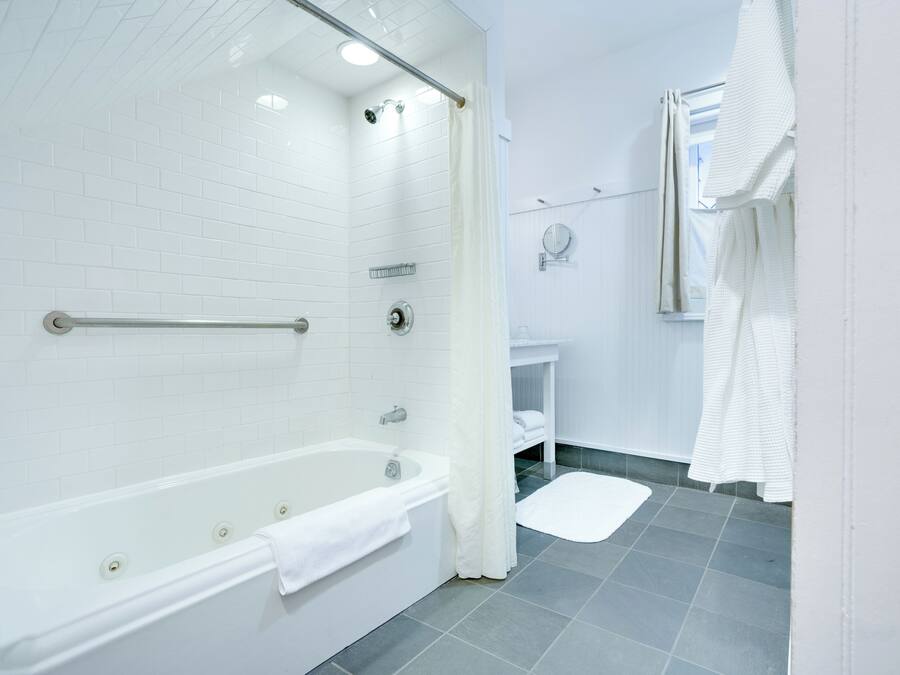 Un baño moderno con una bañera blanca, zona de ducha y lavamanos.