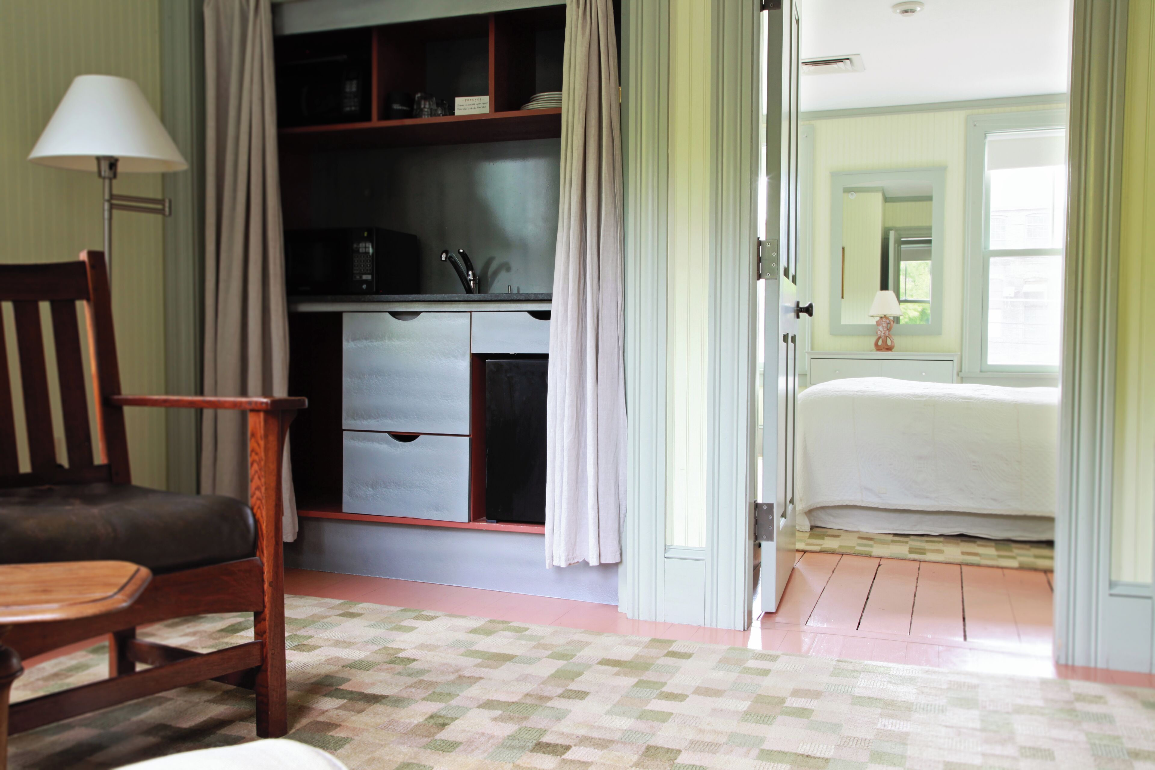 Una habitación con cama, escritorio, silla, armario y ventana.