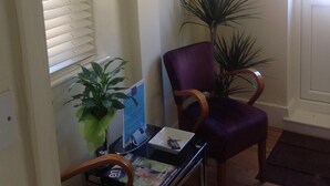 A reception area with a desk, chairs, a plant, and framed artwork on the wall. - The Stag Enfield (Enfield)