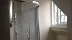 A bathroom with a glass shower enclosure, a toilet, and a sink. - The Stag Enfield (Enfield)