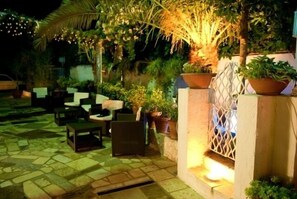An outdoor seating area with stone flooring and potted plants. - Hotel Scigliano (Corigliano-Rossano)