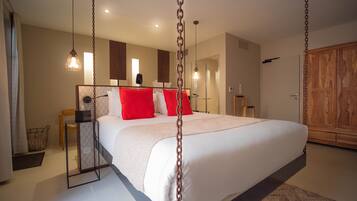 Un dormitorio espacioso con una cama grande, un armario de madera y un espejo sobre la cama.