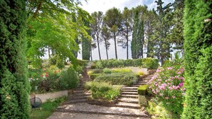 Un jardin avec un escalier en pierre menant à une plateforme d’observation.