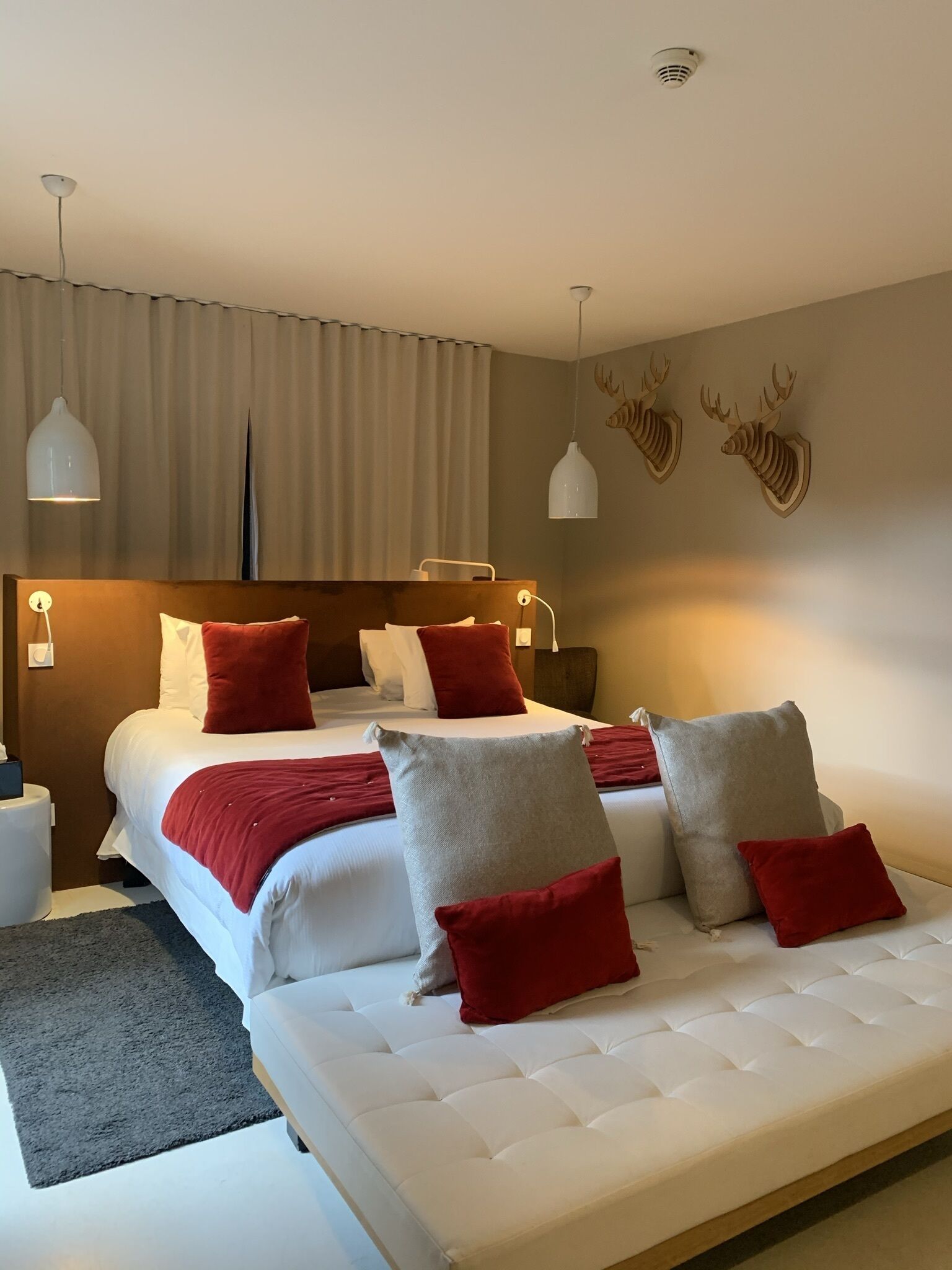 A modern bedroom with a large bed, two bedside tables, and a headboard.