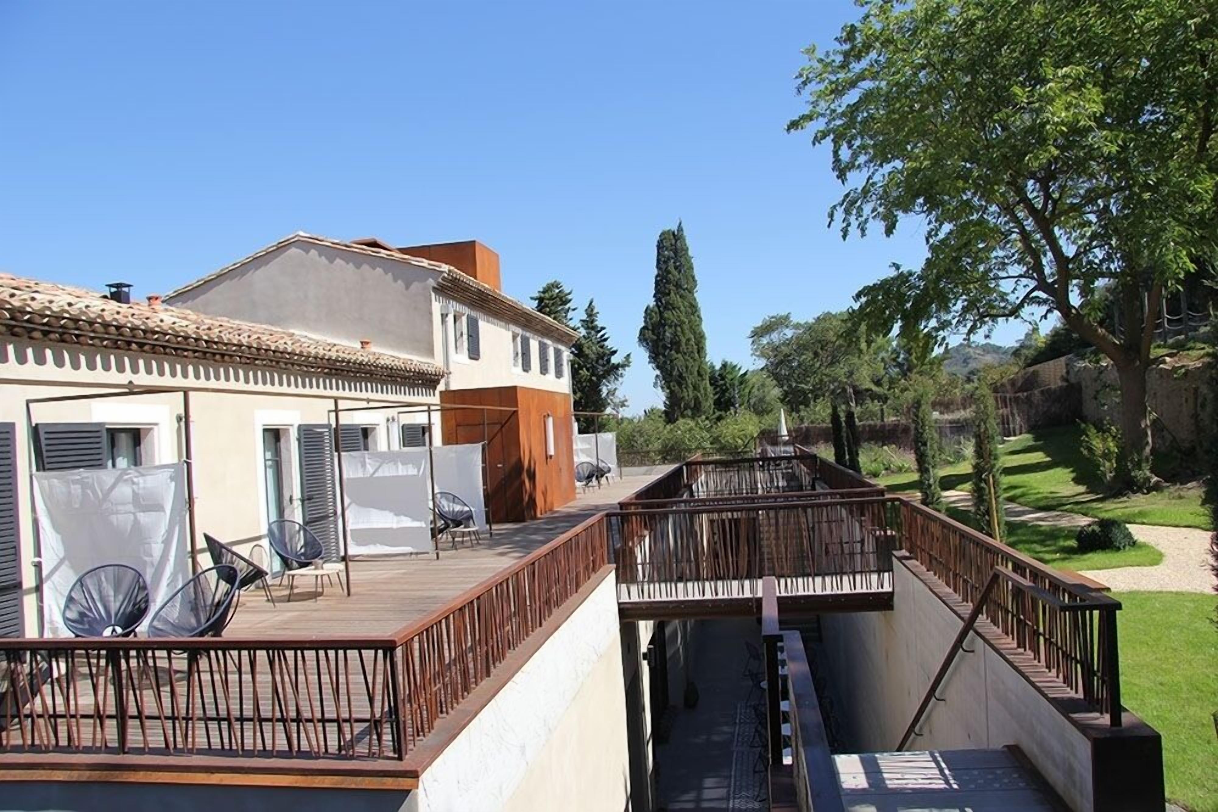 Un immeuble résidentiel doté d’un balcon et d’un espace extérieur aménagé pour s’asseoir.