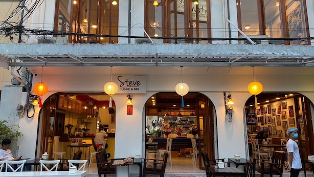 A restaurant with an open-air seating area and a visible entrance. - Steve Lady Hostel (Bangkok)