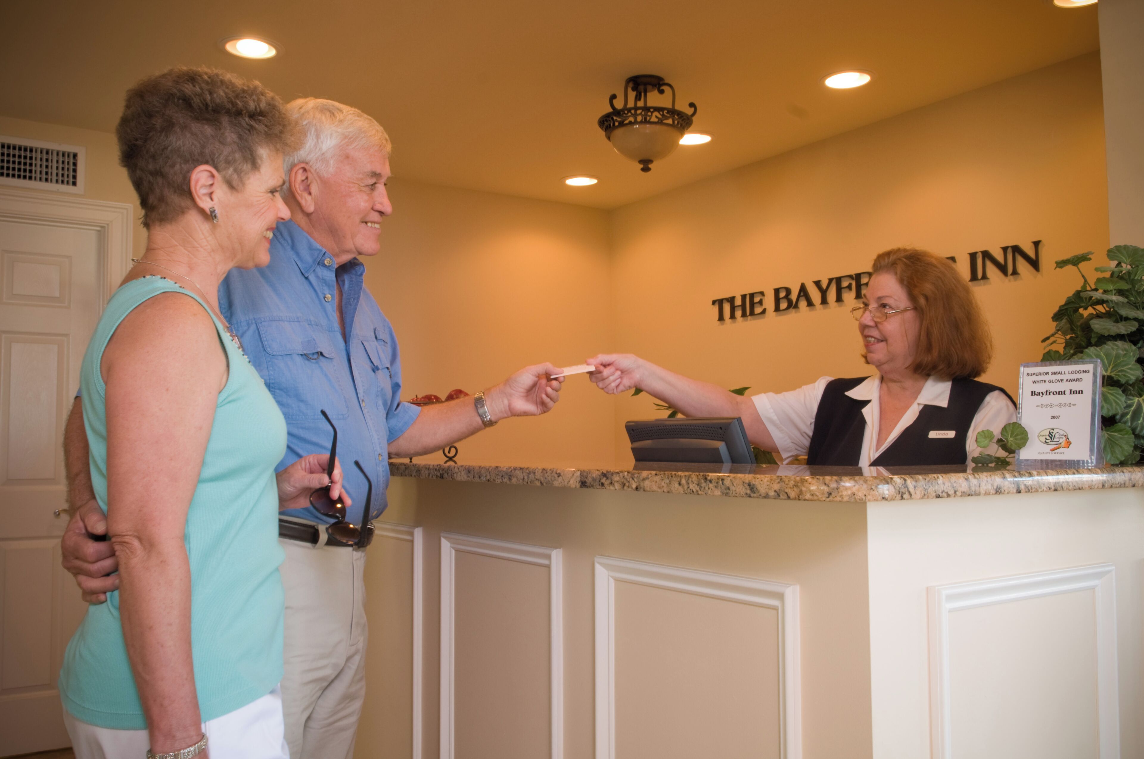 A reception desk at The Bayfront Inn with a sign indicating it is a Superior Small Lodging property.
