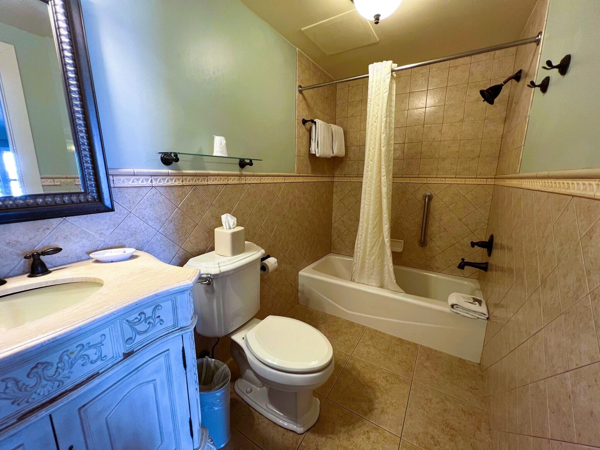 A bathroom with a toilet, sink, bathtub, and shower.