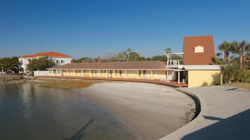 A motel with a long, single-story structure, a covered outdoor seating area, and a small tower-like building.