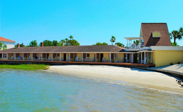 A beachfront motel with multiple rooms, a pool, and a beach view.