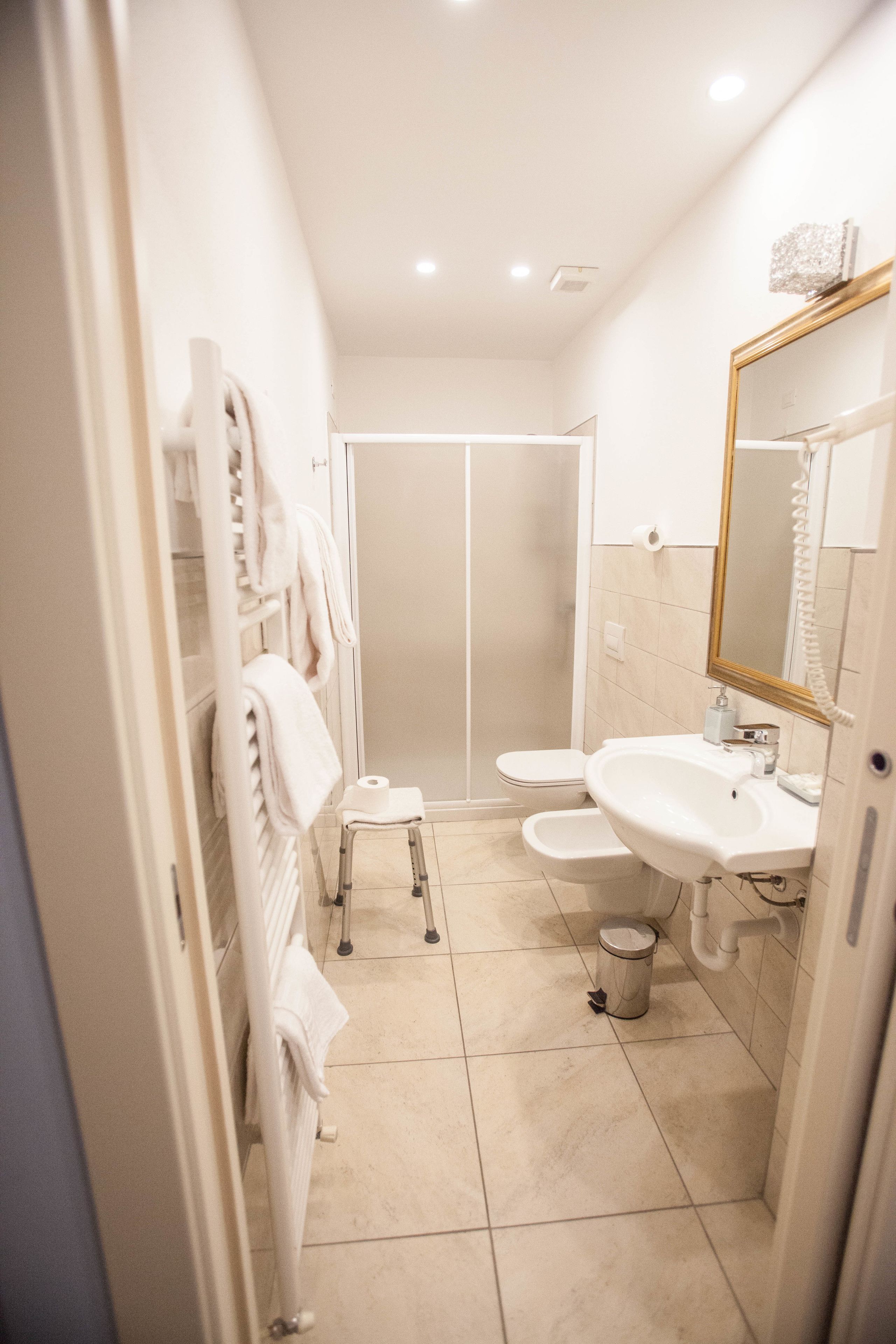 Un baño moderno con ducha a ras de suelo, inodoro y lavamanos.
