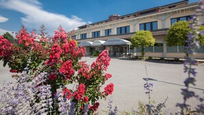 A hotel with a central courtyard, outdoor seating area, and a building facade with signage. - Hotel Ristorante Continental (Osio Sotto)