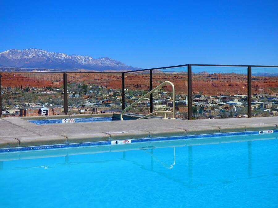 Una piscina con vistas a un pueblo y montañas al fondo.