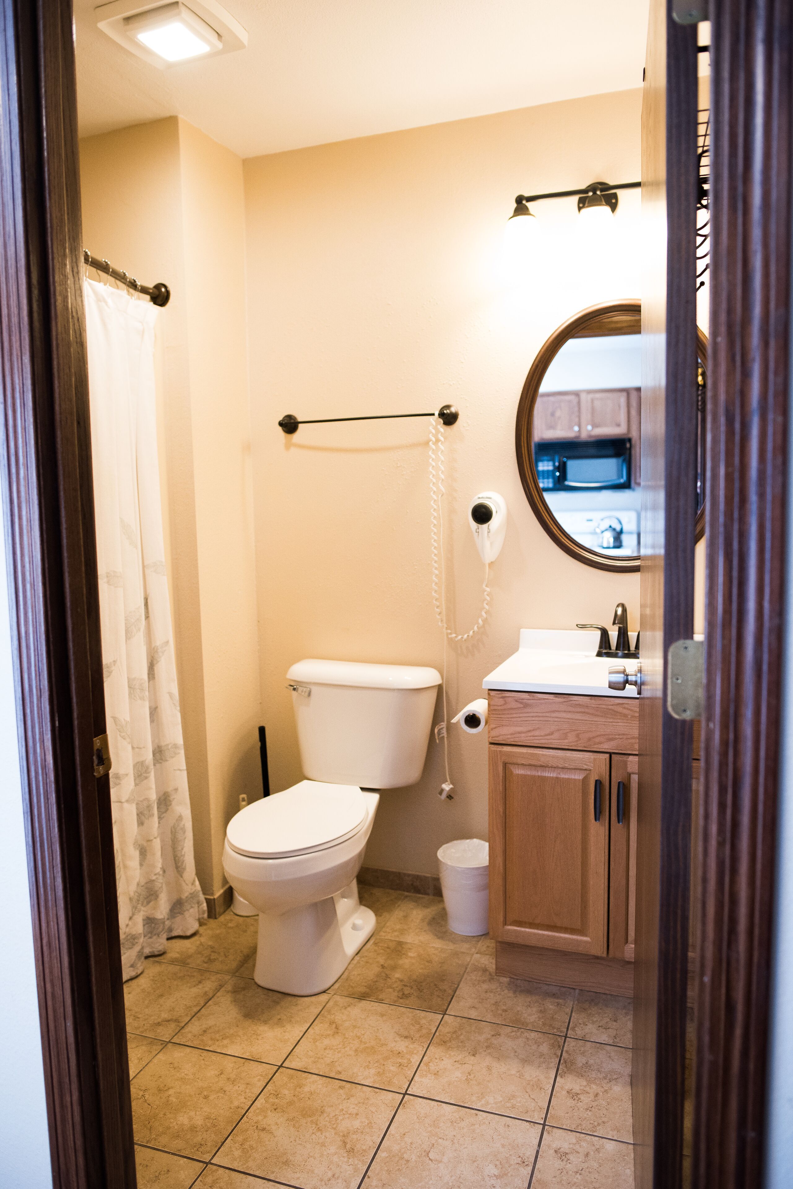 A small bathroom with a toilet, sink, and a mirror.