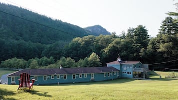 A long, single-story building with a porch and a staircase leading to a second floor.