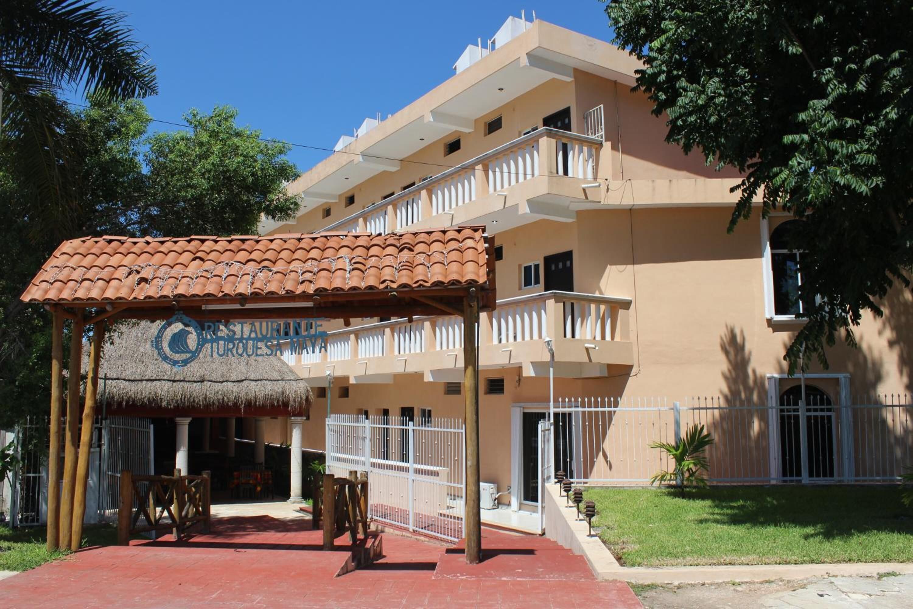 Un edificio con un ristorante chiamato “Restaurante Turquesa” e una zona pranzo all'aperto coperta.