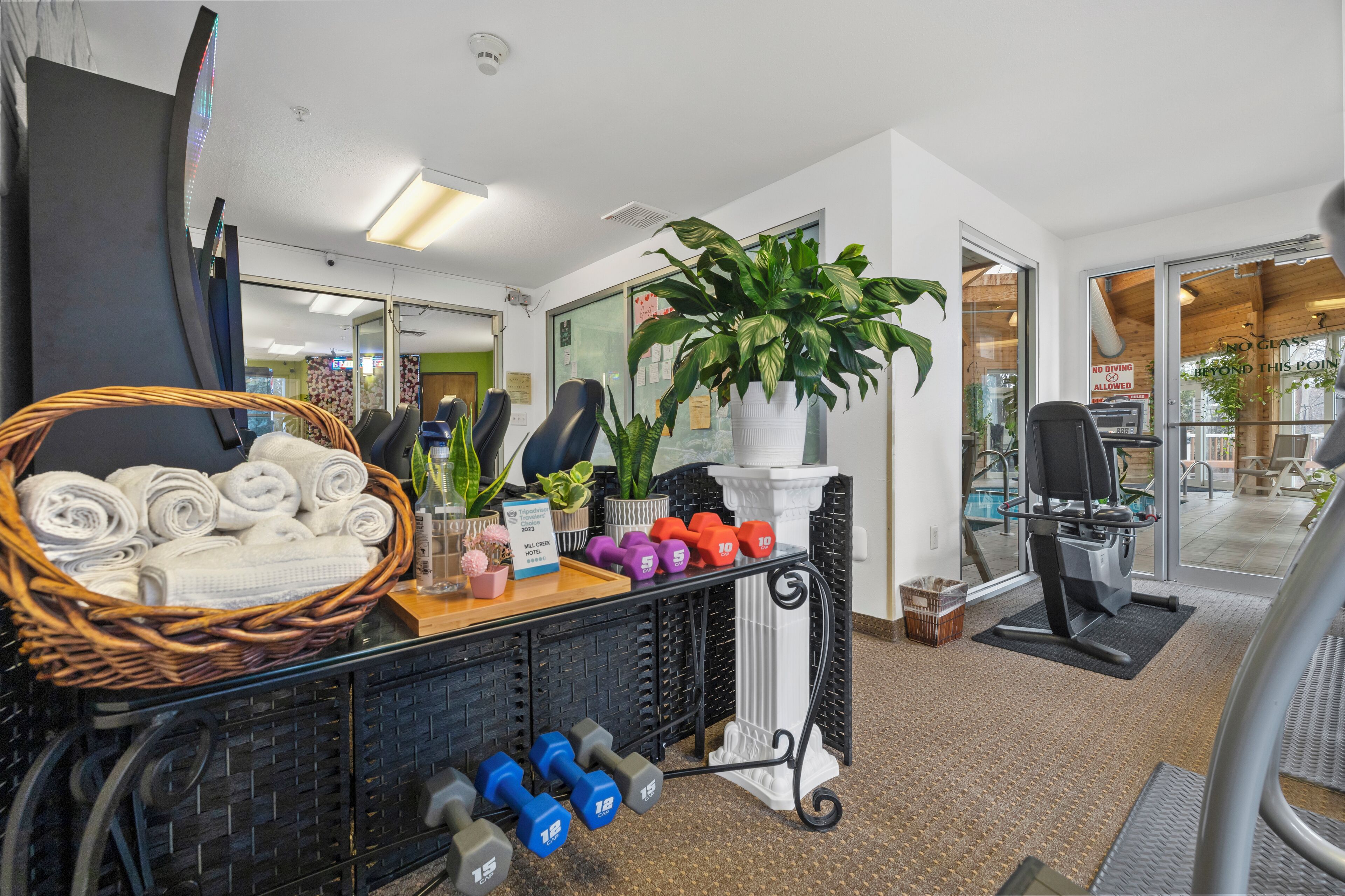 A gym area with exercise equipment, towels, and a basket of towels.
