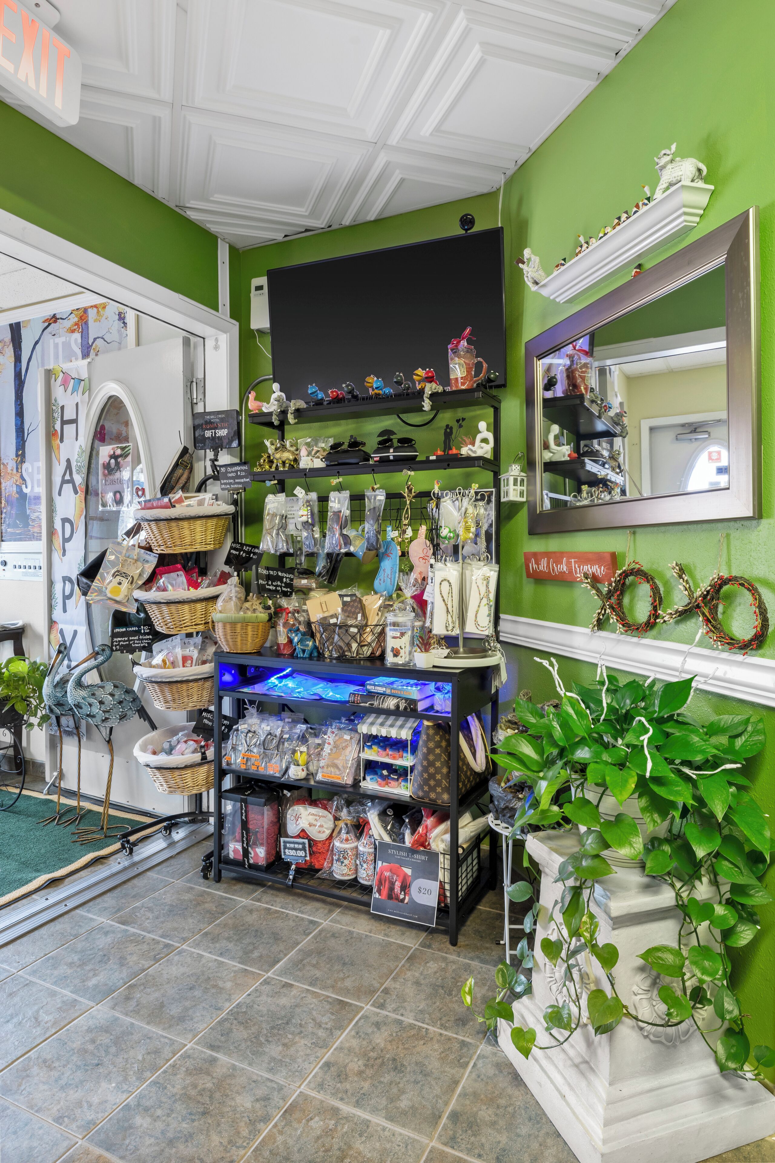 A store with shelves stocked with various items, a mirror, and a sign that says "EXIT".