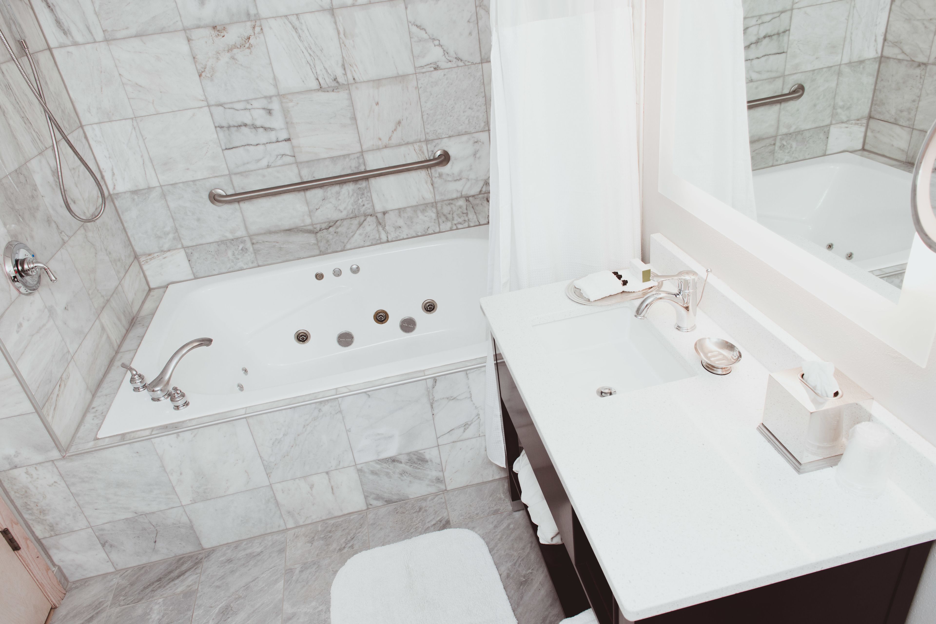 Un baño moderno con bañera, lavabo y espejo.