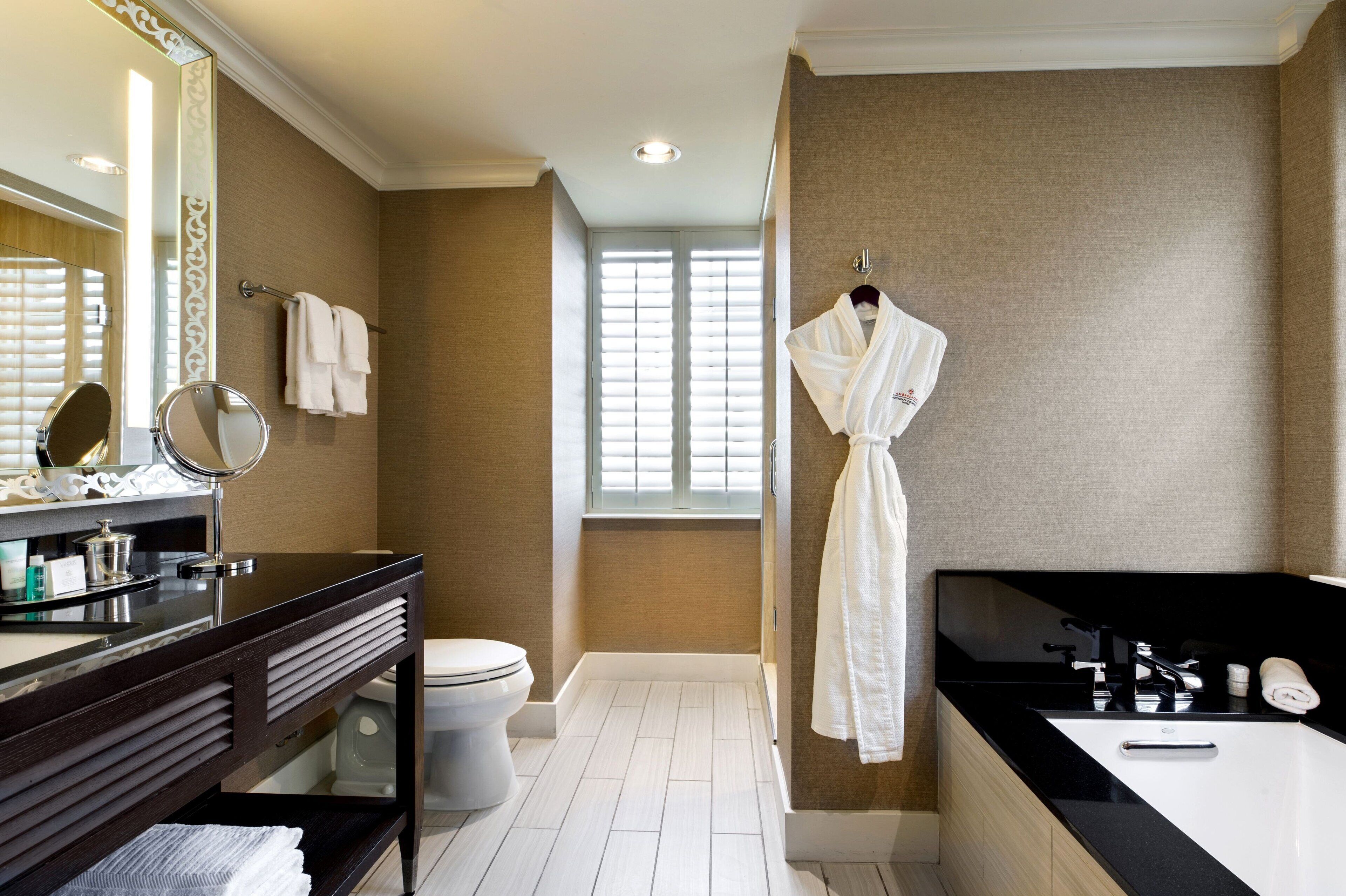 A modern bathroom with a vanity, toilet, and bathtub.