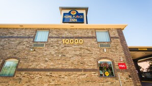 A brick building with a "Home Place Inn" sign, a large number "10000" on the facade, and an "FDC" sign. - Home Place Inn (Houston)