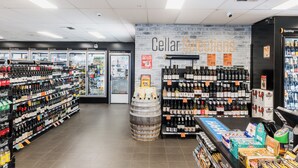 A liquor store with shelves of alcohol, a barrel display, and a sign for 'Cellar Sales'. - Statesman Hotel (Curtin)
