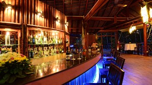 A bar area with wooden beams, a polished bar counter, and a seating area with tables and chairs. - Nataya Roundhouse Coral Bay Resort and Spa (Kampot)