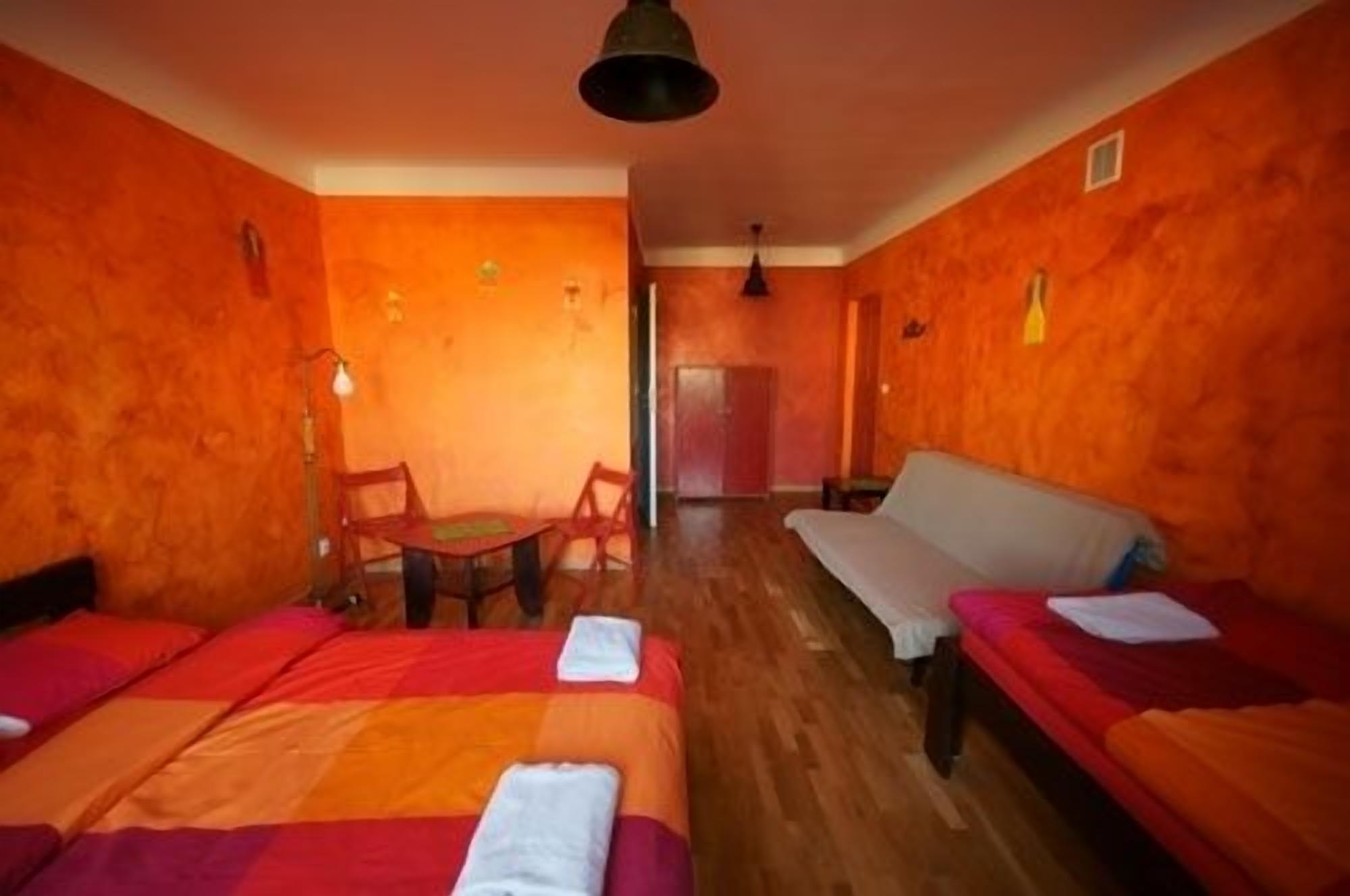 A room with two beds, a sofa, a table, and chairs.
