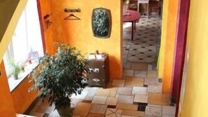 A staircase leading to a room with a tiled floor, a potted plant, and a wall-mounted decoration. - El hostel (Warsaw)
