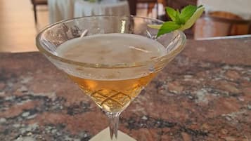 A cocktail in a glass on a marble countertop.