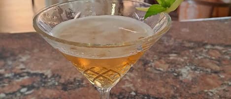 A cocktail in a glass on a marble countertop.