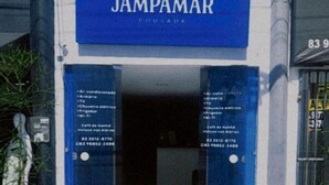 Une entrée d’immeuble avec une enseigne bleue sur laquelle on peut lire « JAMPAMAR POUSADA ».