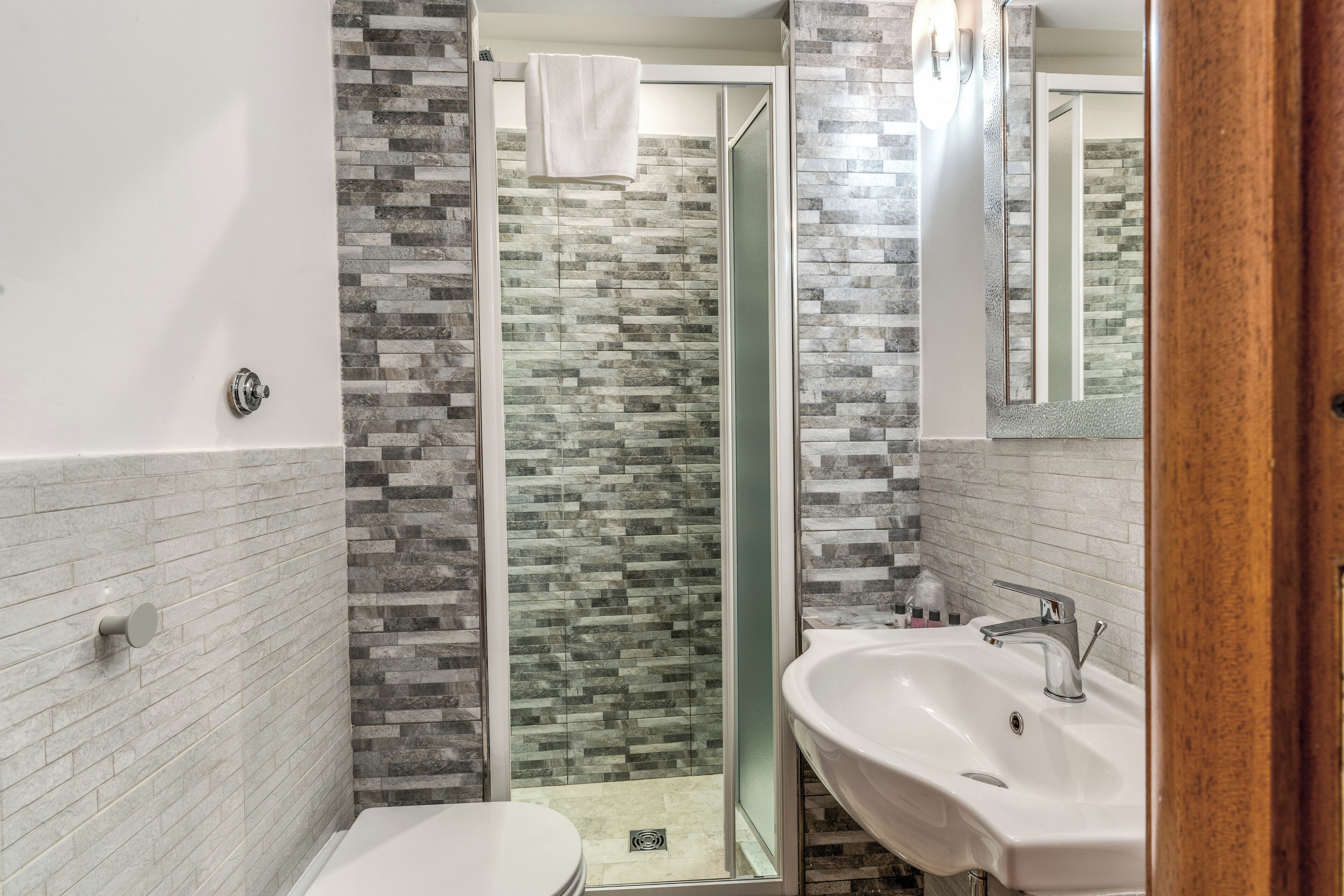 Ein Badezimmer mit Dusche, zwei Waschbecken und Toilette.