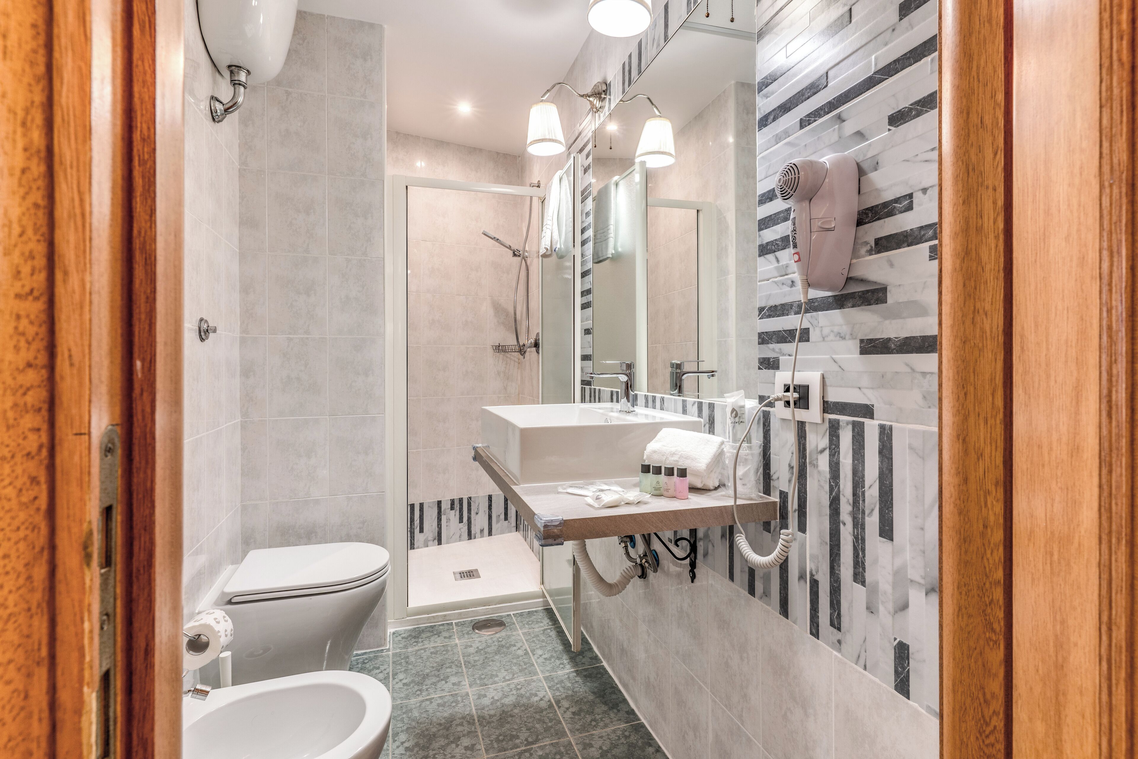 A modern bathroom with a shower, toilet, and vanity.