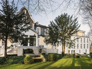 A large, historic building with a prominent tower and multiple windows. - Hotel Park Villa (Wuppertal)
