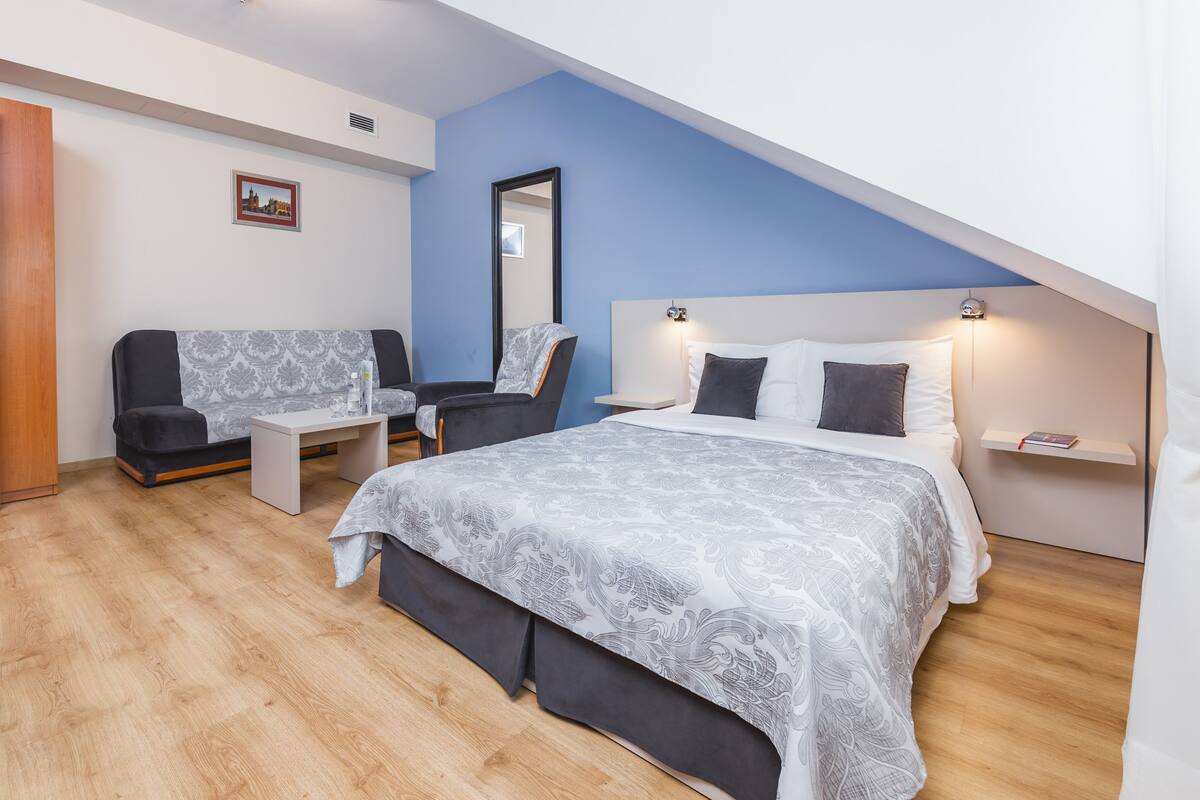 Un dormitorio con una cama, un escritorio, una silla y una mesita.