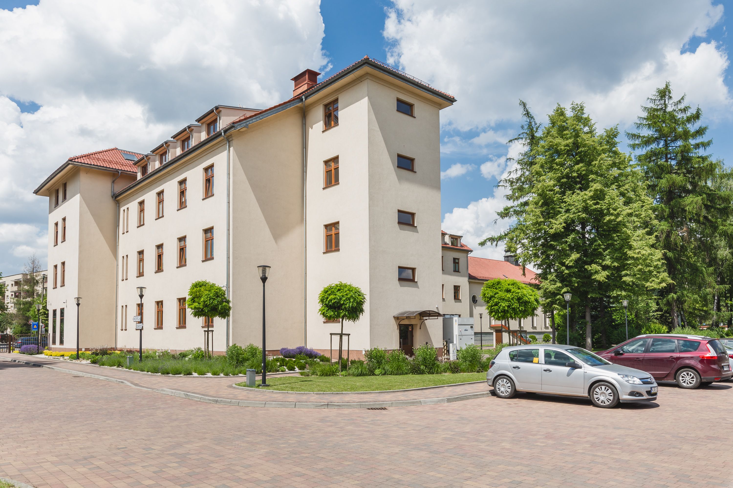 A multi-story building with a flat roof and a paved courtyard.