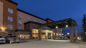 A hotel with a stone facade, multiple windows, and a covered entrance area. - Best Western Plus Fox Creek (Fox Creek)
