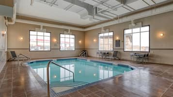 Una piscina techada, sillones reclinables de piscina