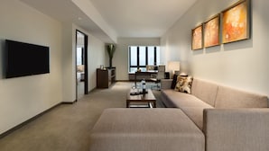 Ein modernes Wohnzimmer mit Flachbildfernseher, einer Couch, einem Couchtisch und Kunstwerken an der Wand.