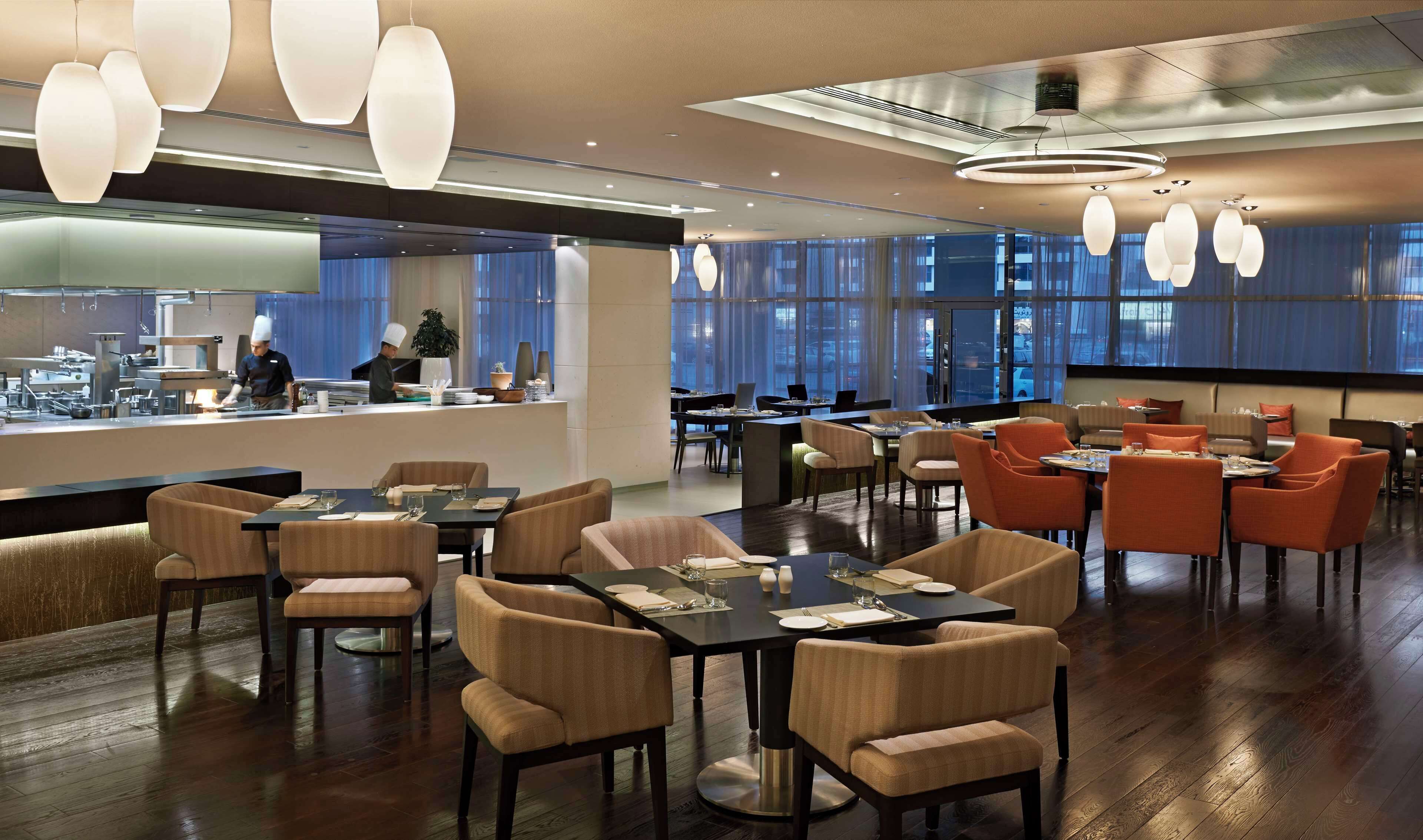 Un restaurant moderne doté d’un bar, de tables et de chaises pour les clients.